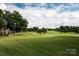 Picturesque golf course view featuring manicured greens, mature trees, and scenic fairways at 16624 Flying Jib Rd, Cornelius, NC 28031