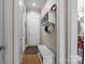 Inviting hallway featuring hardwood floors, white trim, and a convenient bench with storage at 16624 Flying Jib Rd, Cornelius, NC 28031