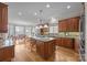 Open kitchen with stone countertops, modern appliances, eat-in island, and adjacent dining area with lake views at 16624 Flying Jib Rd, Cornelius, NC 28031
