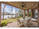 Inviting covered patio with comfortable seating, overlooking a serene lake view at 16624 Flying Jib Rd, Cornelius, NC 28031