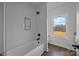Bathroom featuring a tiled shower/tub combination and a window with a view of the outdoors at 1695 Agner Rd, Salisbury, NC 28146