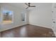 The cozy bedroom features wood floors, a ceiling fan, and windows that provides views of the surrounding nature at 1695 Agner Rd, Salisbury, NC 28146