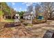 Inviting backyard features a brick patio with seating, a charming swing, and a detached garage at 2418 Acapulco Dr, Gastonia, NC 28054