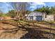Spacious two-car detached garage with white siding is nestled in a backyard with ample space and mature trees at 2418 Acapulco Dr, Gastonia, NC 28054