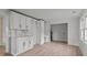 Bright kitchen featuring white cabinets, a modern backsplash, and light wood flooring at 2418 Acapulco Dr, Gastonia, NC 28054