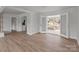 Bright living room showcasing neutral walls, light wood floors, and double doors leading to a sunroom at 2418 Acapulco Dr, Gastonia, NC 28054