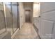 New construction bathroom with tiled walk-in shower featuring glass enclosure, and a view of the walk-in closet at 244 White Apple Way, Statesville, NC 28625