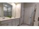 Bathroom featuring double vanity, white cabinetry, framed mirror, and a tiled shower enclosure at 244 White Apple Way, Statesville, NC 28625