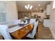 Dining area with table, wainscoting, and light fixture open to the kitchen and living spaces at 244 White Apple Way, Statesville, NC 28625