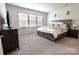 Spacious main bedroom featuring plush carpeting, neutral paint, a decorative ceiling fan, and a large window at 244 White Apple Way, Statesville, NC 28625