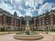 Elegant water fountain sits centered in front of brick apartments under a partly cloudy sky at 300 W 5Th St # 402, Charlotte, NC 28202