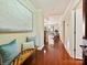 Apartment entryway with hardwood floors, a wooden bench with pillows, and an open view to the living room at 300 W 5Th St # 402, Charlotte, NC 28202