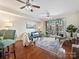 Bright living room with hardwood floors, a ceiling fan, and sliding glass doors to a balcony at 300 W 5Th St # 402, Charlotte, NC 28202
