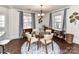 Cozy dining area with hardwood floors, large windows, and a modern chandelier over a glass table at 3016 Hanson Dr, Charlotte, NC 28207