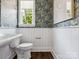 Charming powder room with patterned wallpaper, white wainscoting, and modern fixtures, offering a stylish and functional space at 317 Old Town Village Rd, Waxhaw, NC 28173