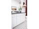 Elegant bathroom vanity with white cabinetry, gold hardware, and stylish black and white patterned flooring at 317 Old Town Village Rd, Waxhaw, NC 28173