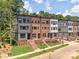 Charming townhome community featuring brick and neutral siding, well manicured lawns and blue skies at 317 Old Town Village Rd, Waxhaw, NC 28173