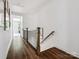 Hallway with wood floors and stairs, offering seamless transition between spaces and highlighting the home's modern design at 317 Old Town Village Rd, Waxhaw, NC 28173