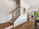 Staircase with wood steps and metal railings complemented by white walls and trim, with natural light, and views into the living space at 317 Old Town Village Rd, Waxhaw, NC 28173