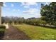 Expansive backyard with lush grass, mature trees, and privacy fencing at 3907 Voltaire Dr, Monroe, NC 28110