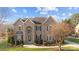 Stunning two-story brick home with a manicured front lawn and mature landscaping at 3907 Voltaire Dr, Monroe, NC 28110