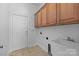 Laundry room featuring tile flooring, sink, and storage cabinets at 3907 Voltaire Dr, Monroe, NC 28110