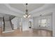 Spacious living room with hardwood floors, staircase, and elegant light fixtures at 3907 Voltaire Dr, Monroe, NC 28110
