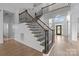 Elegant staircase with dark wood railings and a view of the front door at 3907 Voltaire Dr, Monroe, NC 28110