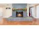 Close up of brick fireplace with wood mantle and lit fire at 401 Dakota St, Kannapolis, NC 28083