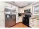 Spacious kitchen equipped with stainless steel fridge, oven, and microwave, plus white cabinetry at 401 Dakota St, Kannapolis, NC 28083