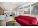 Bright sunroom with many windows, neutral floors, and red couch, perfect for relaxation and views of the outdoors at 401 Dakota St, Kannapolis, NC 28083