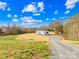Serene property showcasing a single-story home with a gravel driveway and ample yard space at 4055 10Th Avenue Sw Dr, Hickory, NC 28602