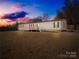 Inviting single-story home with a classic white facade and a charming front porch at dusk at 4055 10Th Avenue Sw Dr, Hickory, NC 28602