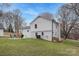 Spacious backyard featuring a fire pit with chairs, white siding, and well-kept lawn at 437 Chadmore Dr, Charlotte, NC 28270