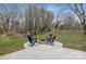 Outdoor patio with a stone fire pit and four black Adirondack chairs perfect for entertaining at 437 Chadmore Dr, Charlotte, NC 28270