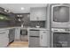 Stylish kitchenette with gray cabinets, appliances, herringbone backsplash and laundry machines at 437 Chadmore Dr, Charlotte, NC 28270
