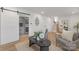 Open living area with hardwood flooring, staircase, and barn door access to the utility room at 437 Chadmore Dr, Charlotte, NC 28270