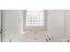 Clean garden tub featuring white tile and bright window at 464 Hurston Cir, Charlotte, NC 28208