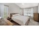 Cozy bedroom featuring a rustic wooden bed frame, soft lighting, and windows offering a serene view at 464 Hurston Cir, Charlotte, NC 28208