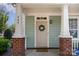 Inviting front porch features brick accents, white columns, and a charming wreath on the front door at 464 Hurston Cir, Charlotte, NC 28208