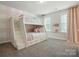 Charming bedroom featuring a bunk bed, carpet, and two windows with pink curtains at 5140 Oak Grove Pl, Waxhaw, NC 28173