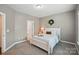Calm bedroom featuring soft gray walls, plush carpeting, a comfortable bed, and a bright window at 5140 Oak Grove Pl, Waxhaw, NC 28173
