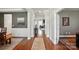 Elegant hallway with hardwood floors, neutral paint, and decorative trim showcasing an open floor plan at 5140 Oak Grove Pl, Waxhaw, NC 28173