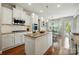 Well-lit kitchen featuring white cabinetry, stainless steel appliances, granite countertops, and hardwood floors at 5140 Oak Grove Pl, Waxhaw, NC 28173