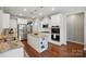 Modern kitchen with stainless steel appliances, granite countertops, a center island with storage, and hardwood floors at 5140 Oak Grove Pl, Waxhaw, NC 28173