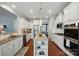 Contemporary kitchen with white cabinets, stainless steel appliances, granite countertops, a center island, and hardwood floors at 5140 Oak Grove Pl, Waxhaw, NC 28173