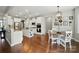 Spacious, well-lit kitchen featuring white cabinetry, stainless steel appliances, granite countertops, and hardwood floors at 5140 Oak Grove Pl, Waxhaw, NC 28173