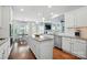 Bright, open kitchen with white cabinets, stainless steel appliances, granite countertops, a center island, and hardwood floors at 5140 Oak Grove Pl, Waxhaw, NC 28173