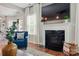 Inviting living room featuring a cozy fireplace with a large TV above it, plus hardwood floors and bright natural light at 5140 Oak Grove Pl, Waxhaw, NC 28173