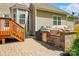Outdoor kitchen with built-in grill on a brick paver patio and steps leading to a wooden deck at 5140 Oak Grove Pl, Waxhaw, NC 28173